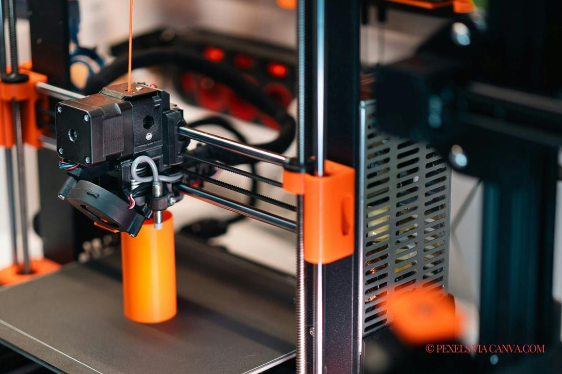Prusa brand 3D printer printing an orange cylinder.