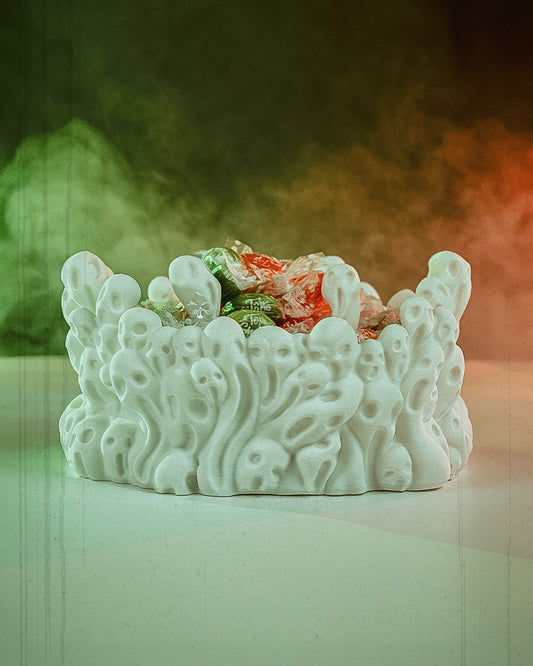Close-up of spooky skull-themed 3D printed candy bowl filled with assorted candies, West Texas 3D printing. Includes a spooky filter showing fog and green and orange lighting