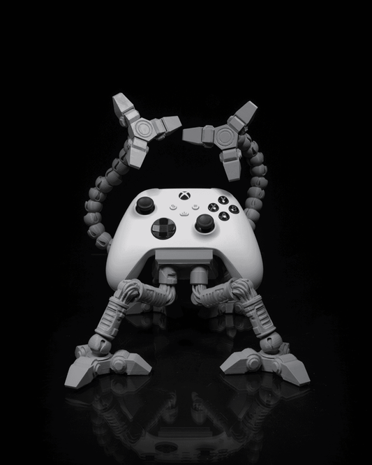 Gray articulated controller holder with Xbox controller, robotic arms raised.