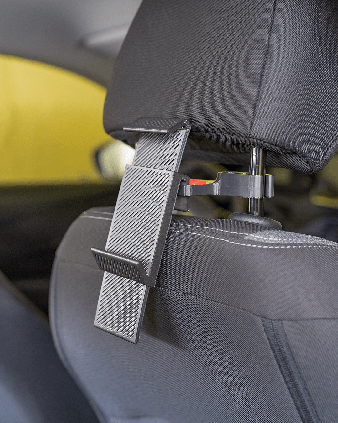 Phone holder component of AutoEase Complete Passenger Kit mounted behind headrest