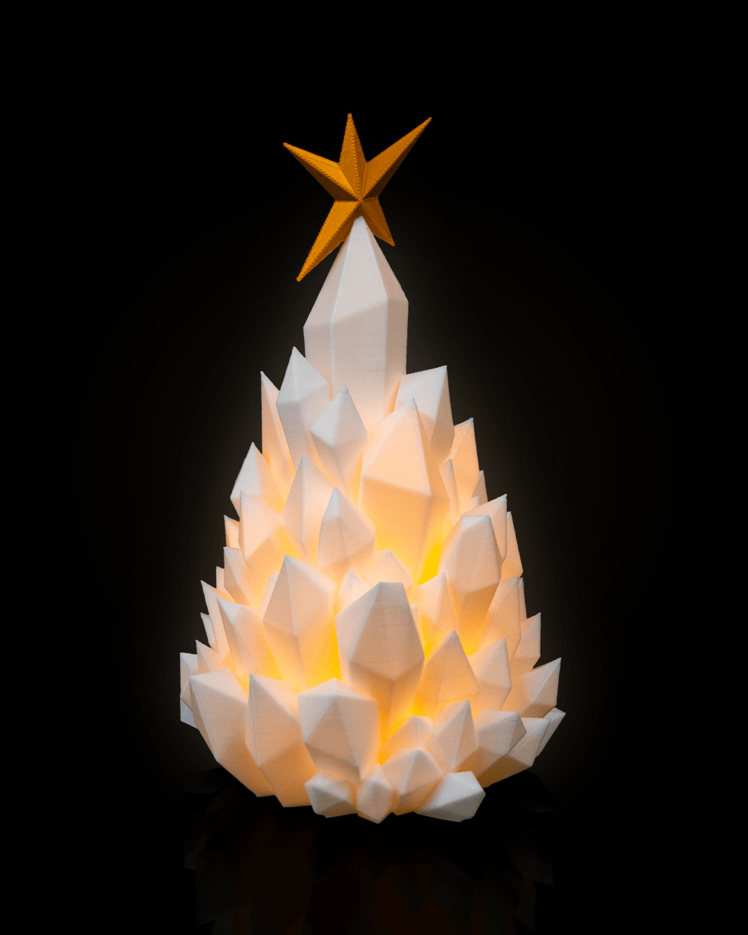 3D printed Cryst-mas Tree illuminated with electric tea candle, featuring crystal-style texture and golden star topper.