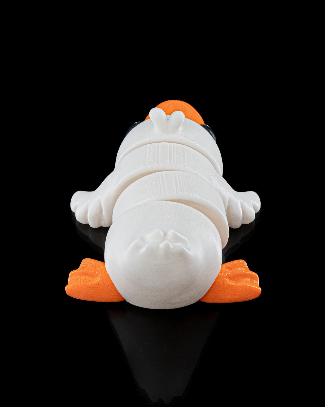 3D printed Cute Flexi Duck articulated toy in white and orange, shown from the back on a black background.
