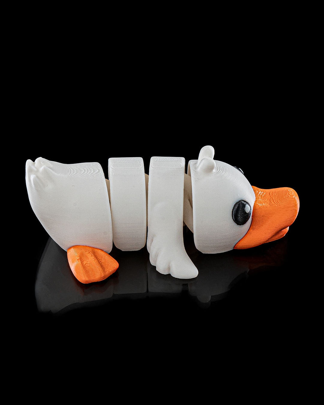 3D printed Cute Flexi Duck articulated toy in white and orange, shown from the side on a black background.