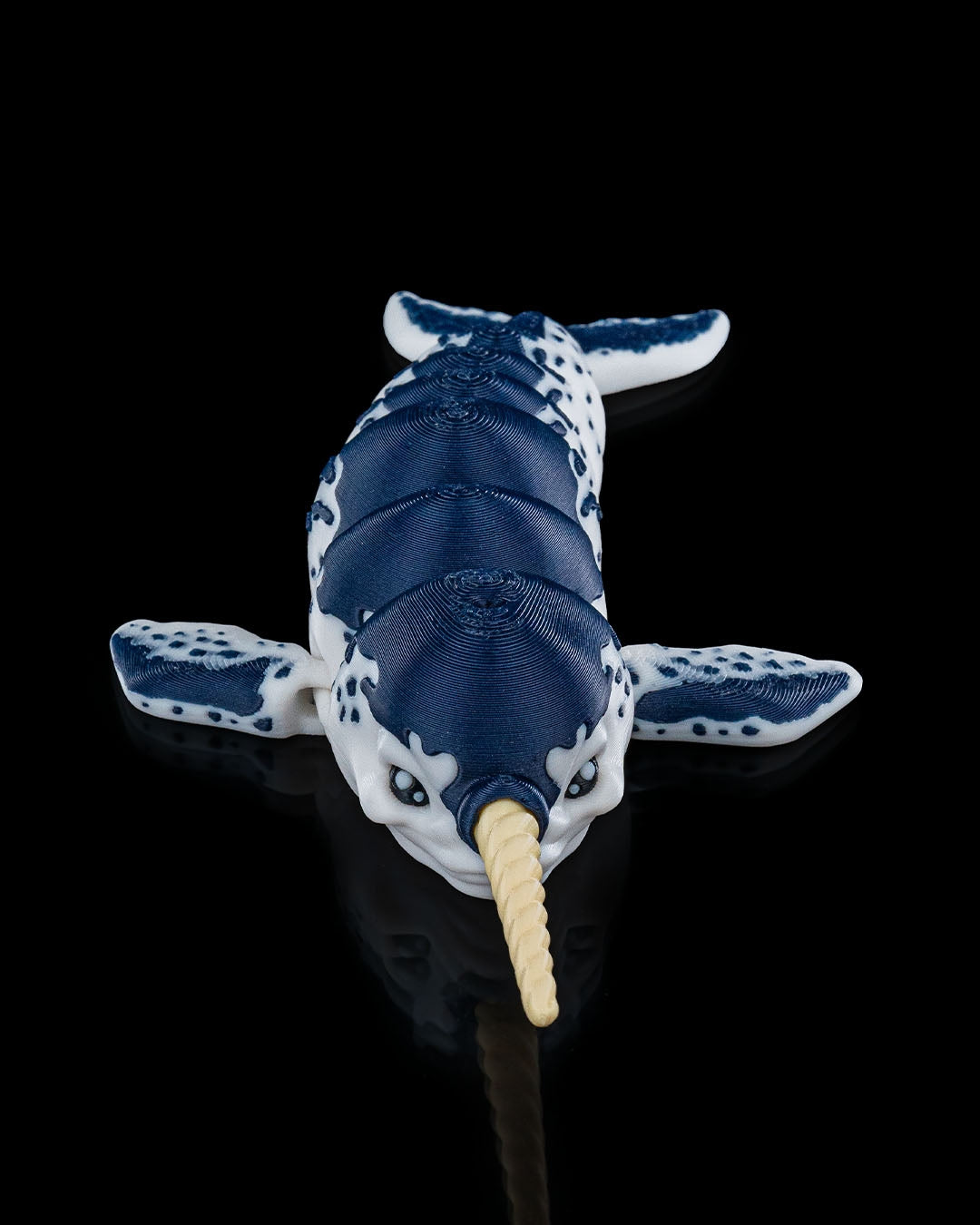 3D printed Flexi Narwhal toy shown in a front-angled view with blue-and-white coloring and articulated body.