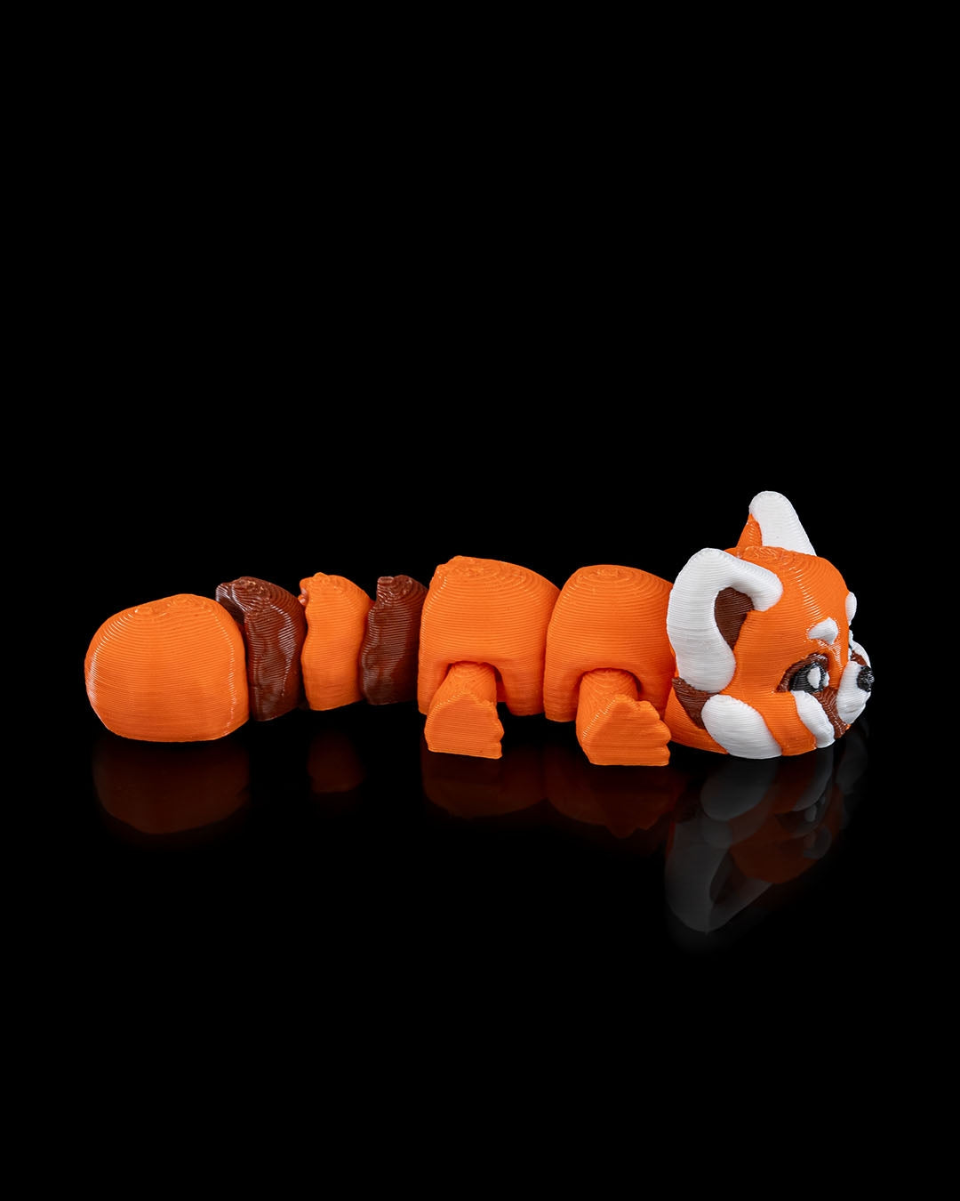 Side view of the 3D printed articulated red panda toy in a crawling position.