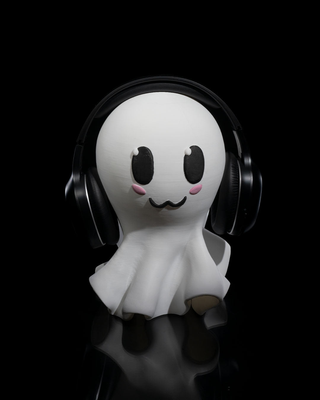 3D printed Ghost Headphone Holder with cute painted ghost face holding headphones.