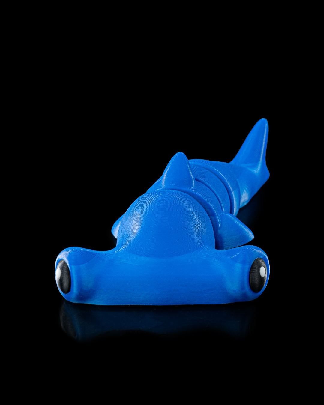 Angled view 3D printed blue flexi hammerhead shark toy shown on black background with articulated segments