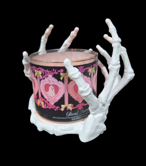 Angled view of Large Light Touch Skeleton Hands Candle Holder holding a Bath & Body Works 3-wick candle
