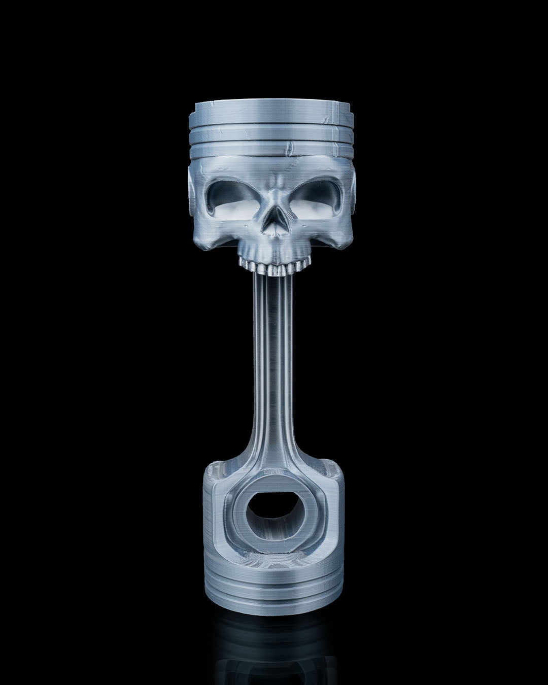 3D printed Piston Skull Headphone Holder in metallic silver.