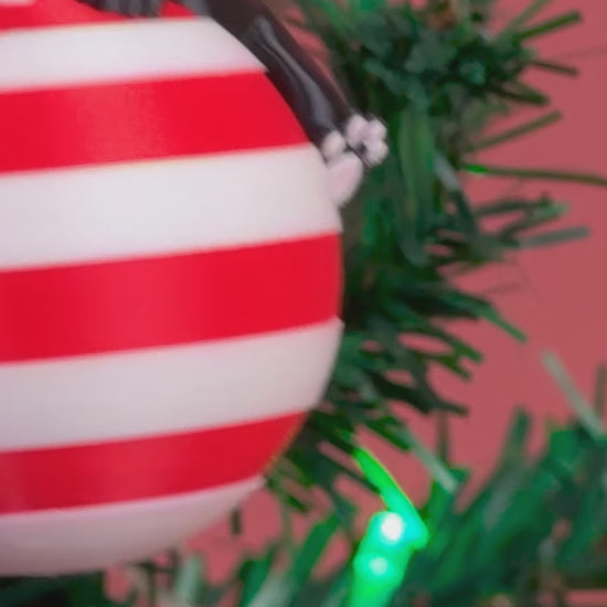 Rotating video of the Sleepy Pup Ornament showing all angles of the dog figure on a candy-striped ball.