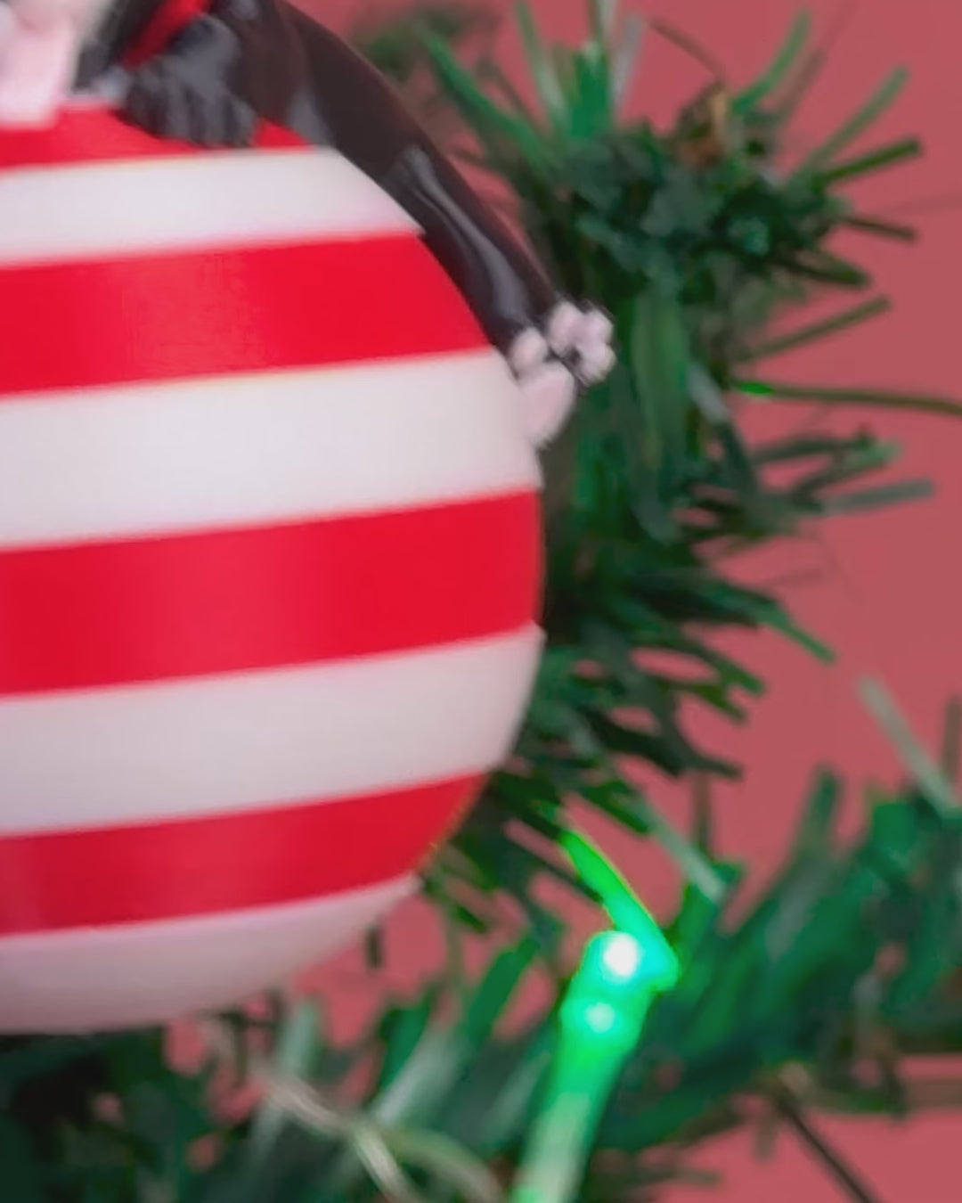 Rotating video of the Sleepy Pup Ornament showing all angles of the dog figure on a candy-striped ball.