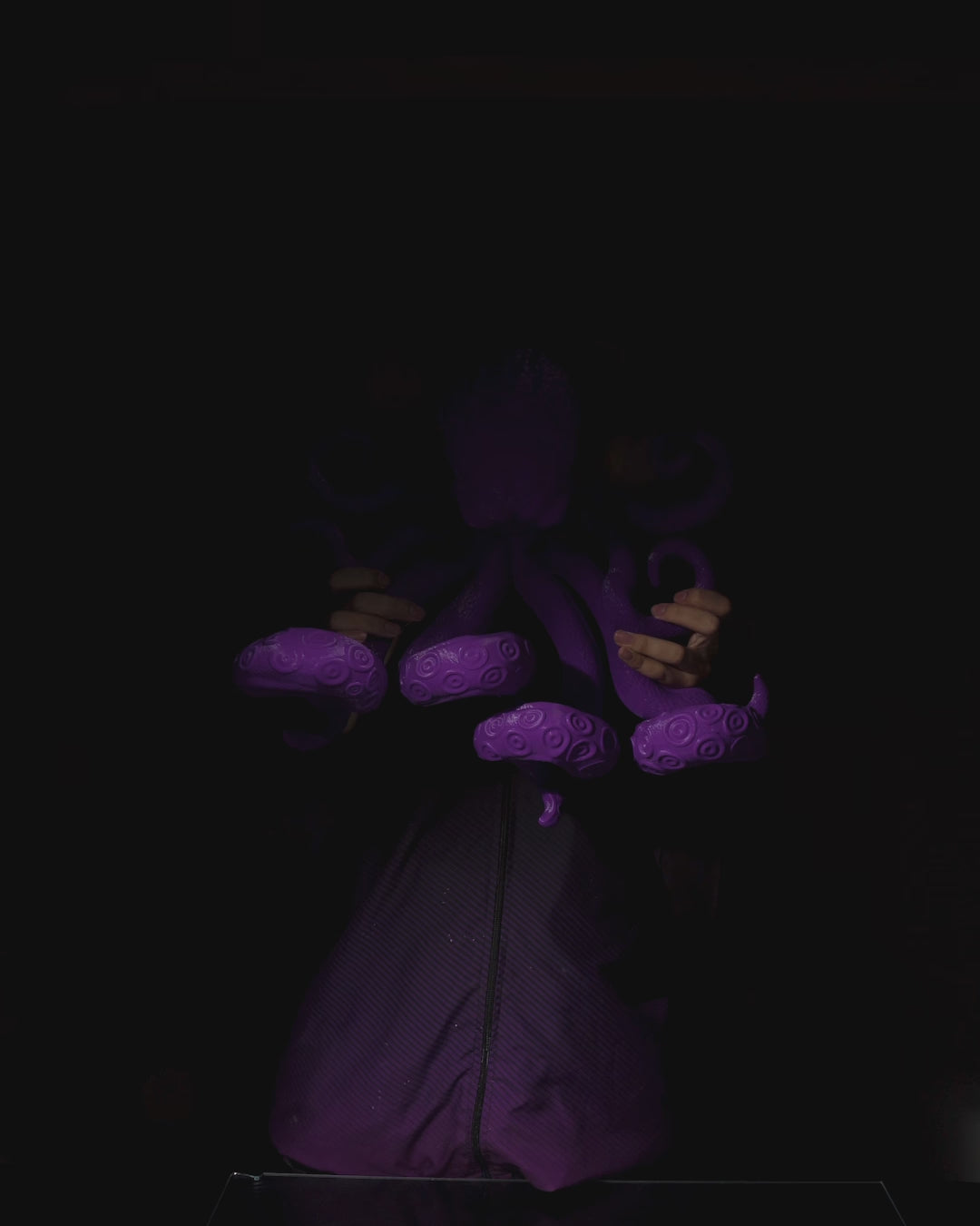 360 view of purple Octopus tentacles holding a gaming controller.