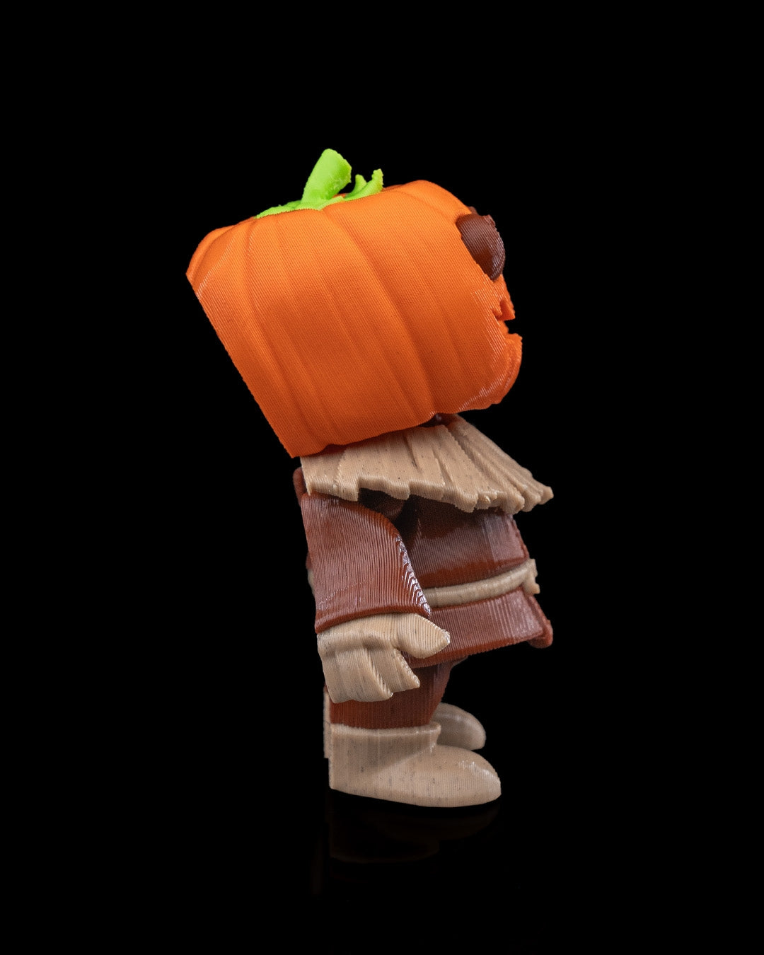 Side view of the Scarecutie Scarecrow showing detailed layered clothing and carved pumpkin-style face.