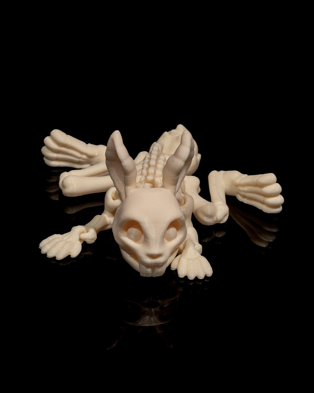 flat view of Skeleton Fidget Bunny 3D print in beige PLA showing rib and limb articulation.
