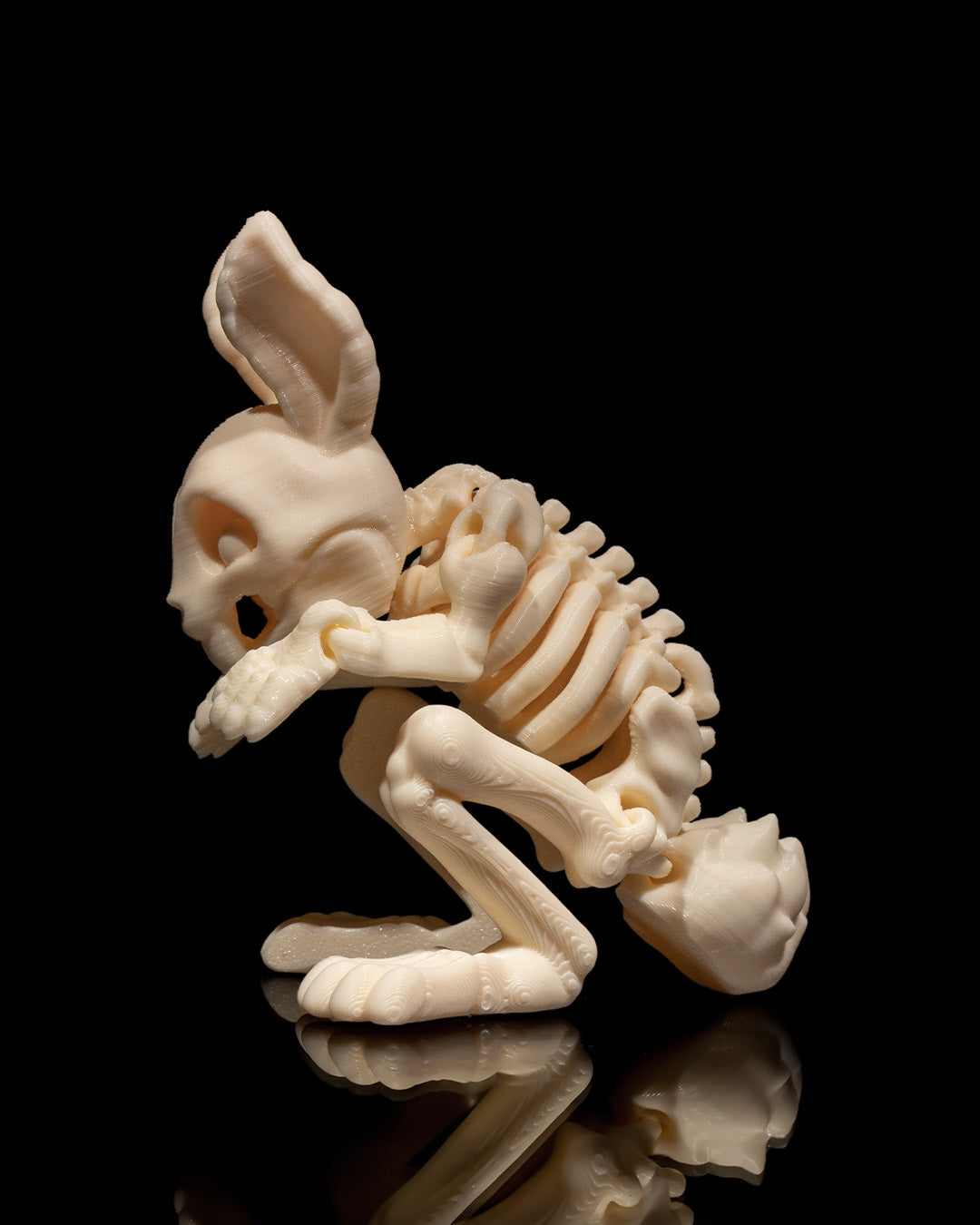 Side profile of Skeleton Fidget Bunny 3D print in beige PLA showing rib and limb articulation.