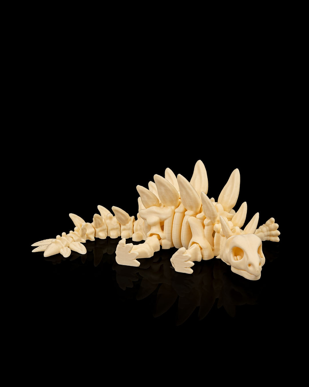 Angled view of 3D printed Skeleton Stegosaurus miniature lying flat displaying detailed plates and limbs.