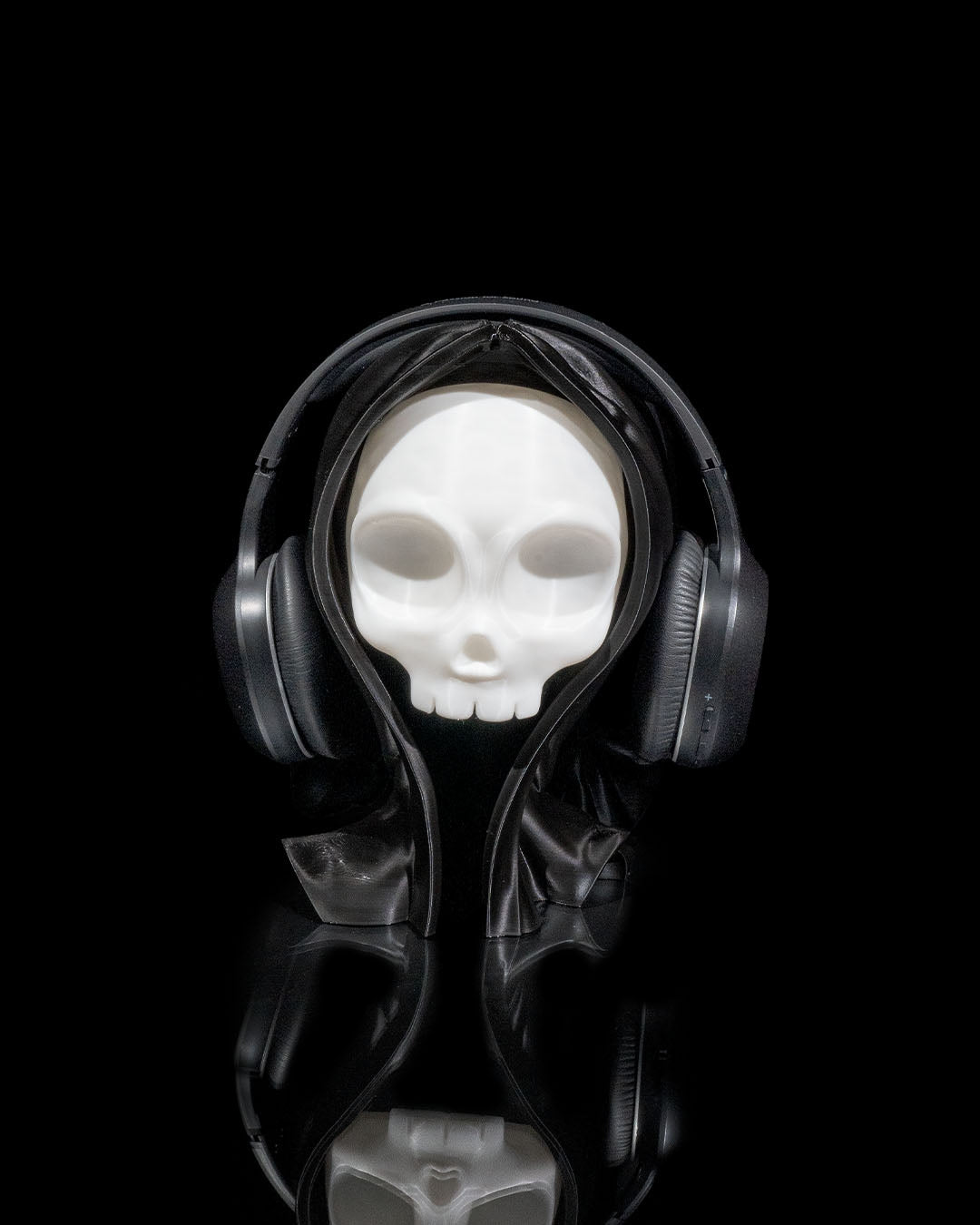 3D printed Skull Headphone Holder stand in white PLA with headphones displayed