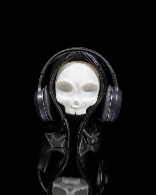 3D printed Skull Headphone Holder stand in white PLA with headphones displayed