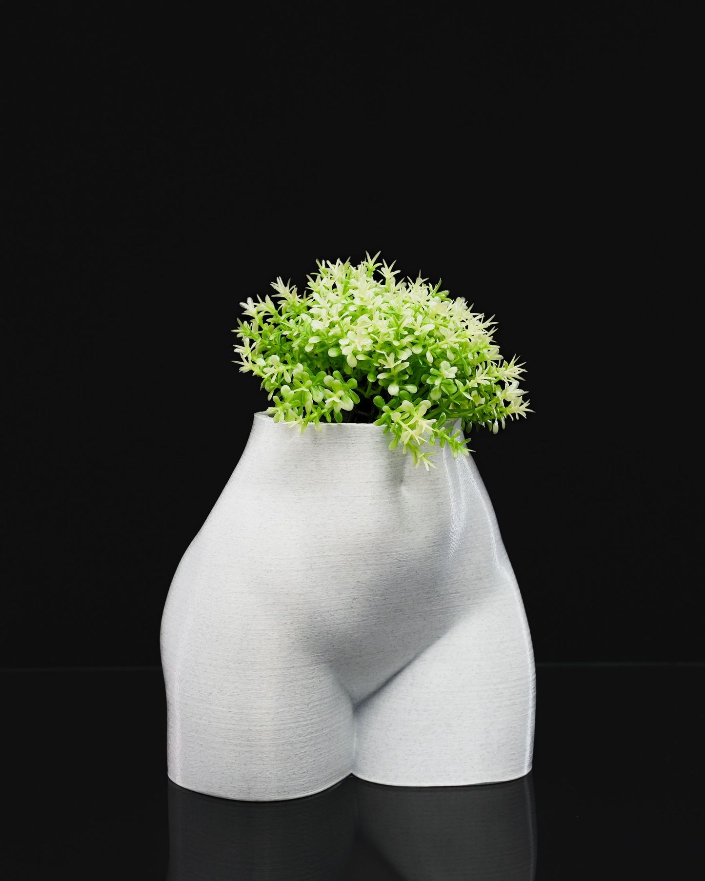 Female Summer Body Vase in PETG holding a plant, showcased on black background.